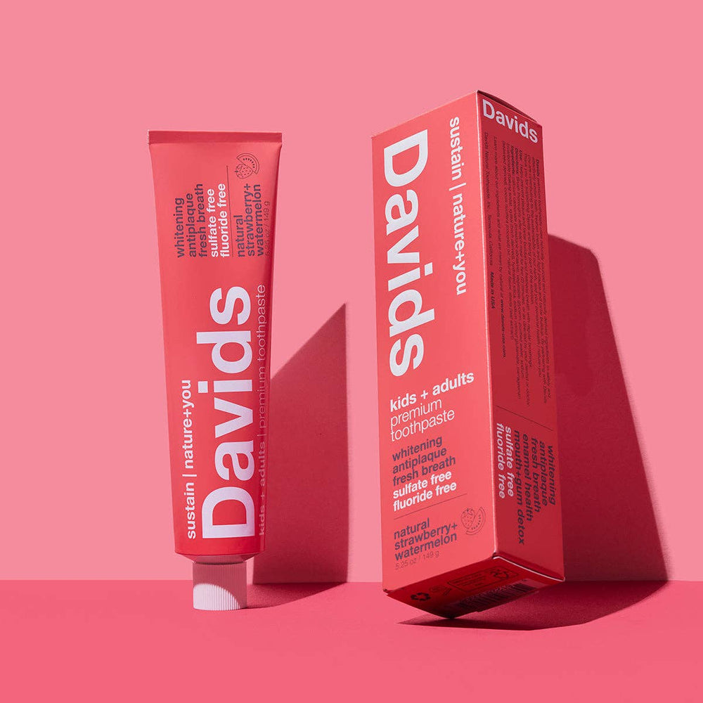 Davids toothpaste tube and box on a pink background
