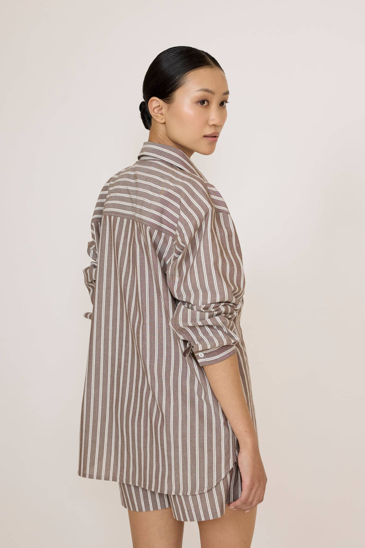 Woman wearing a Laude Everything Shirt in Acorn Stripe and matching shorts set on a plain background