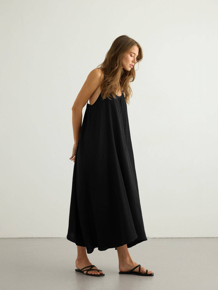 Woman wearing a black maxi dress against a white background