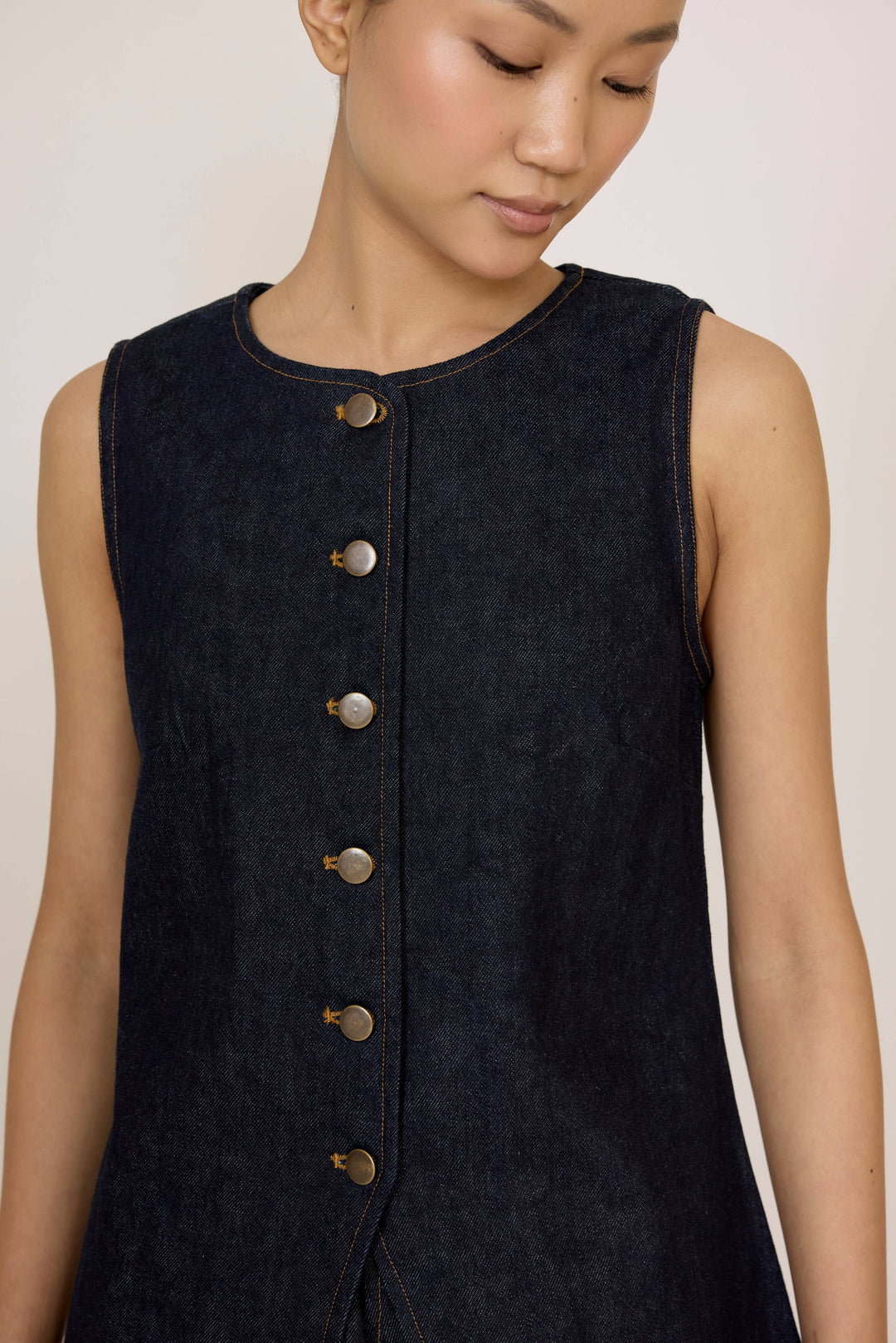 Woman wearing a Laude Longline Vest in Dark Indigo over a plain background