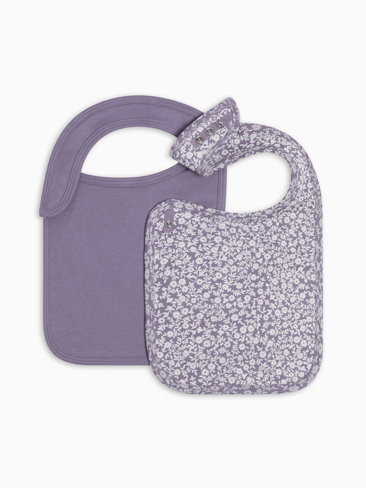 Two lavender baby bibs on a white background, one solid lavender and the other with a small white floral print.