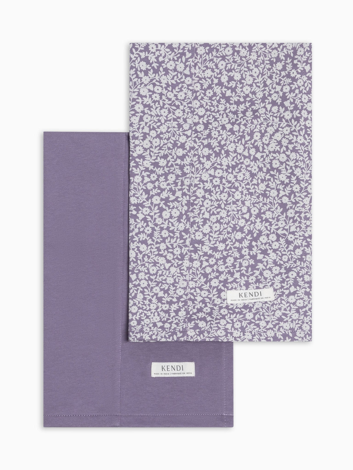 Two lavender burp cloths from colored organics, one with a white floral pattern and one solid lavender, displayed on a clean white background.
