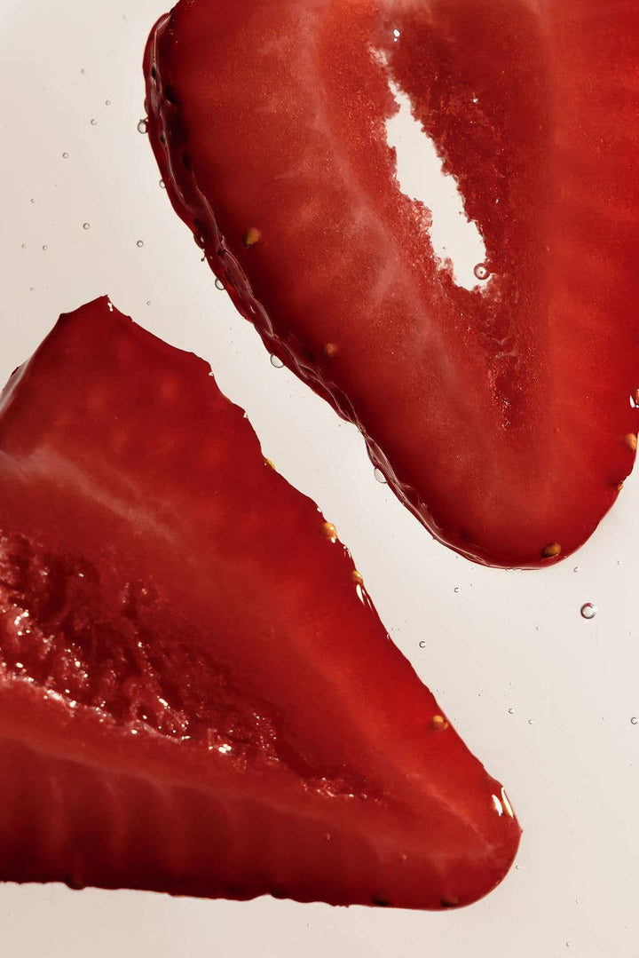 Close-up of two sliced red strawberries on a plain white background.
