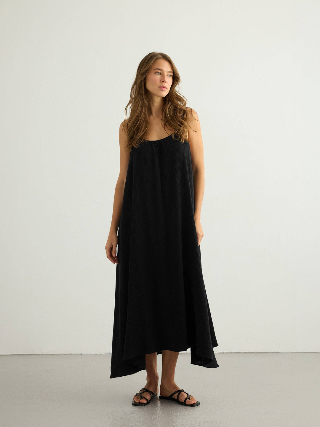 Woman wearing a black dress against a white background