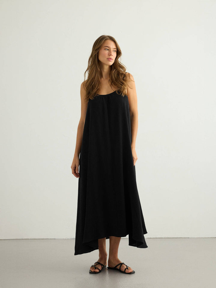 Woman wearing a black dress against a white background