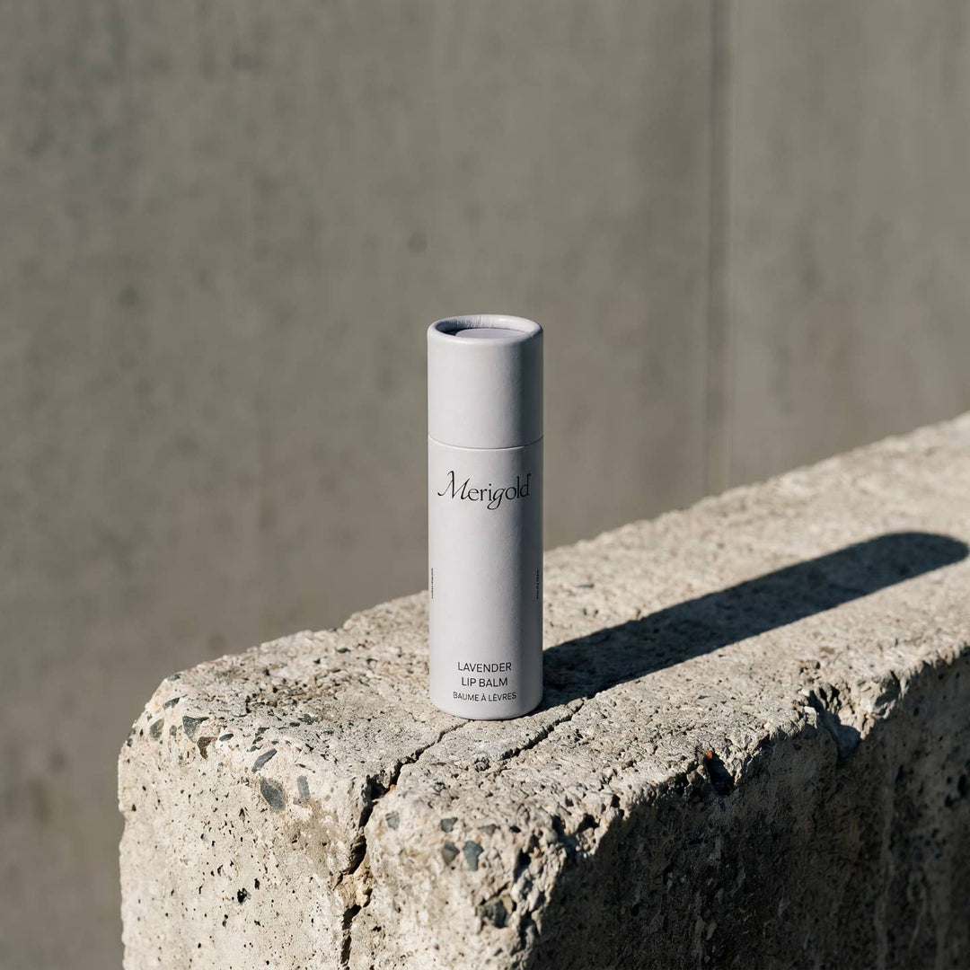Lip balm container on a concrete surface with a neutral background