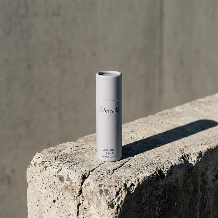 Lip balm container on a concrete surface with a neutral background