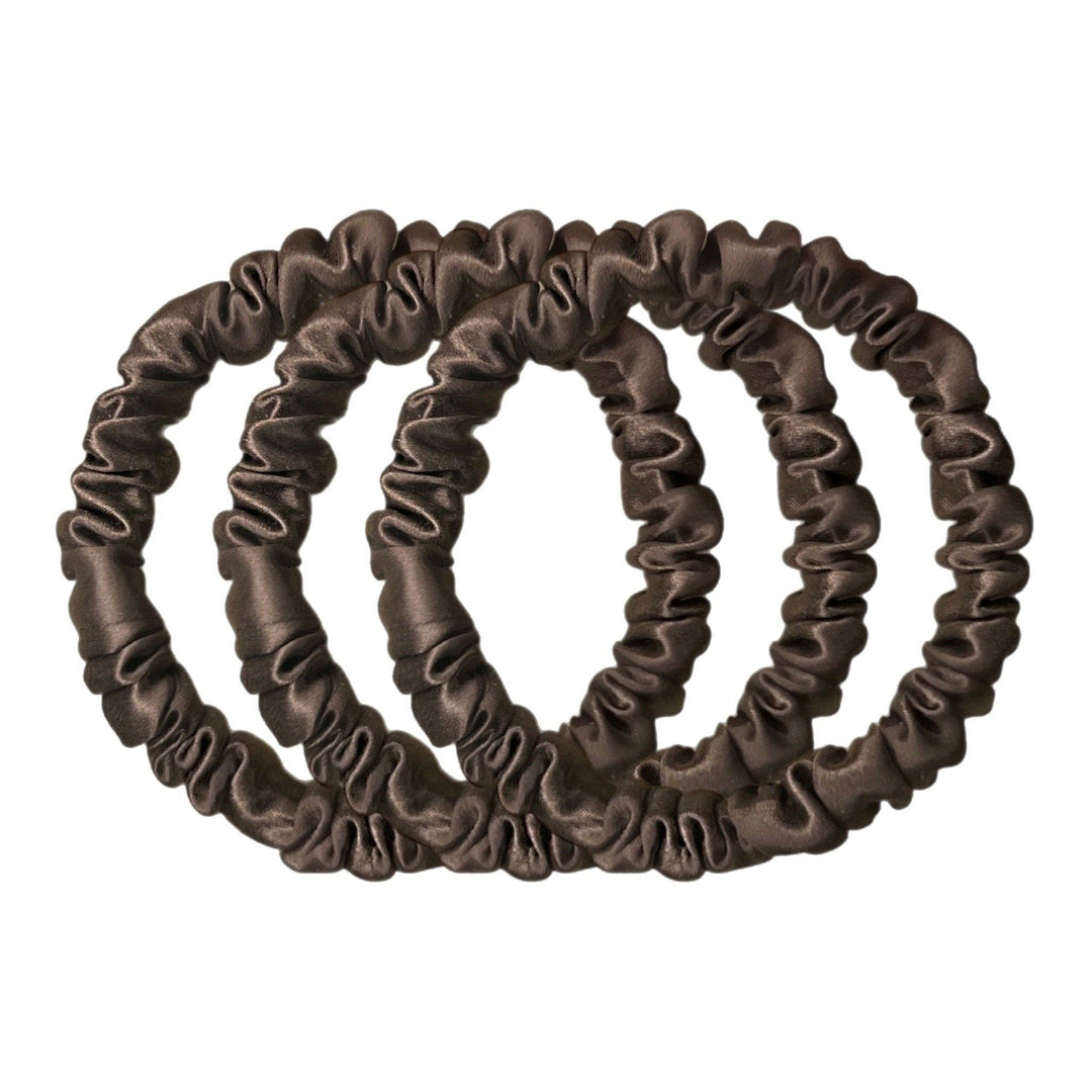 Set of three brown silk hair scrunchies on a white background