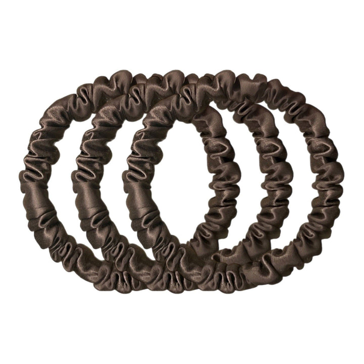 Set of three brown silk hair scrunchies on a white background