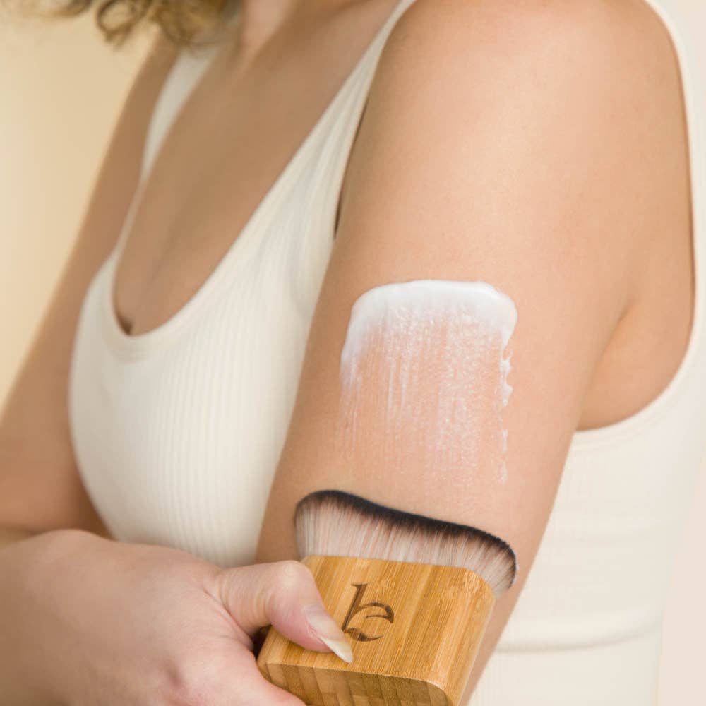 Person applying a tanning cream to their arm with a Self Tanner Blending Body Brush