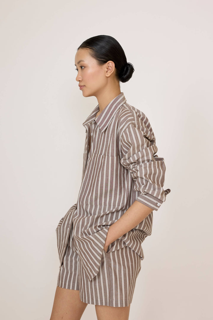 Woman wearing a Laude Everything Shirt in Acorn Stripe and matching shorts set on a plain background