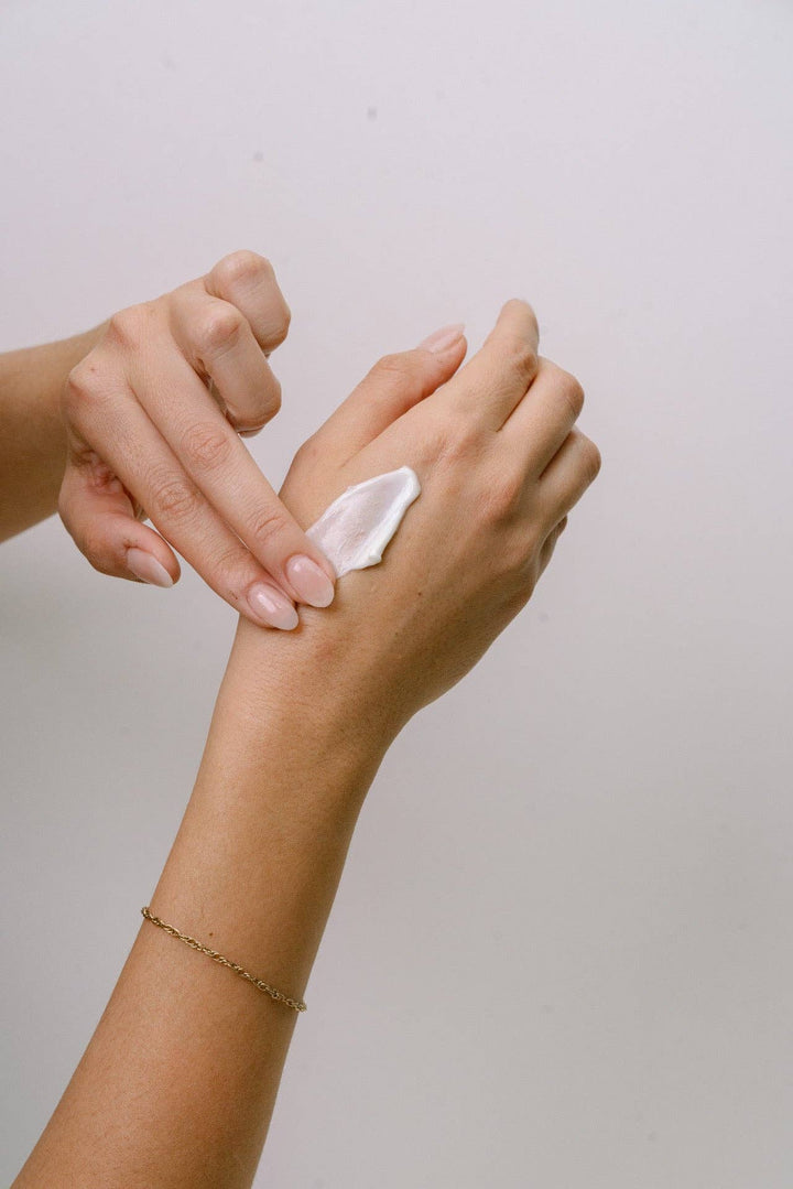 Person applying Lavender Eucalyptus Hand Cream to their wrist with a neutral background