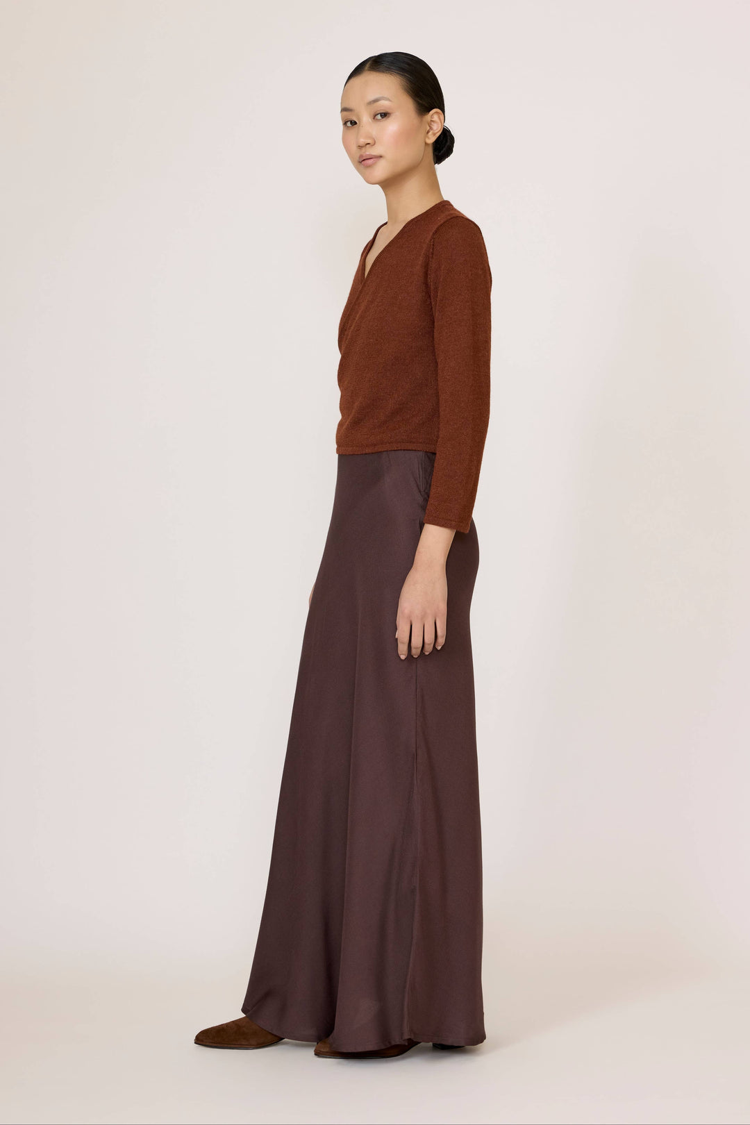 Woman wearing a brown top and Bias Maxi Skirt in Chocolate Brown on a white background