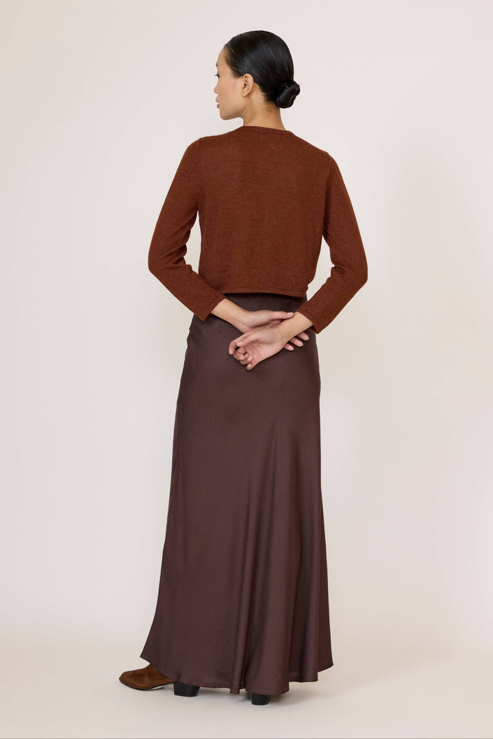 Woman wearing a brown top and Bias Maxi Skirt in Chocolate Brown on a white background