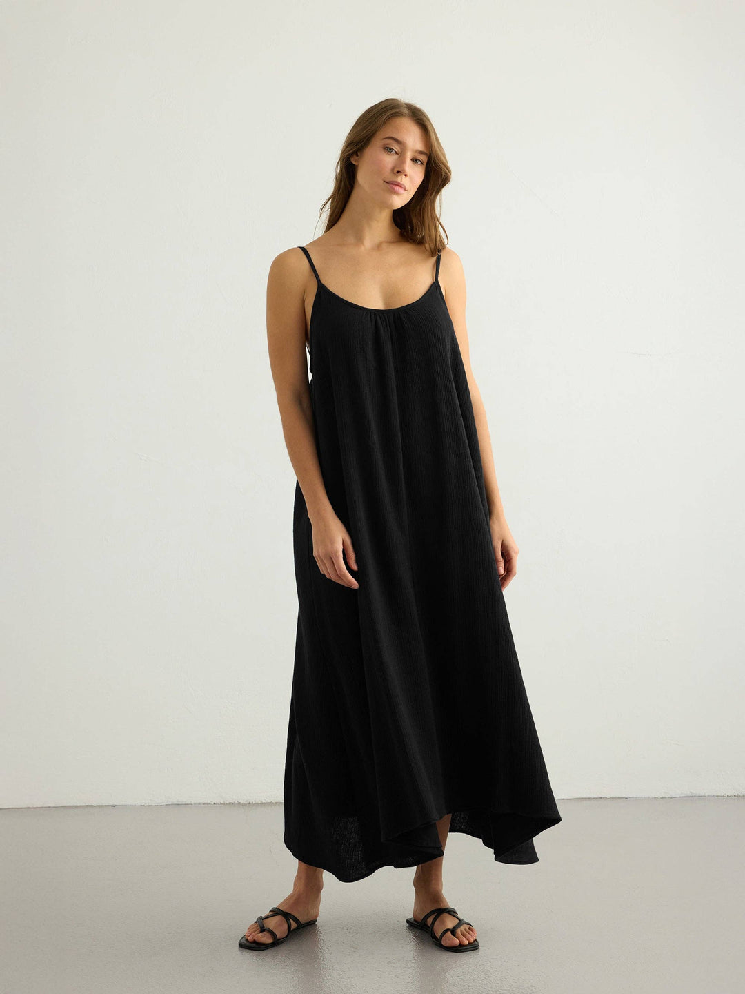 Woman wearing a black maxi dress against a white background