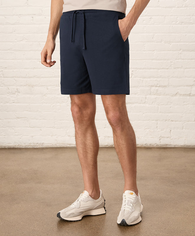 Pact Stash French Terry Short in Midnight Blue Front View with Sneakers.