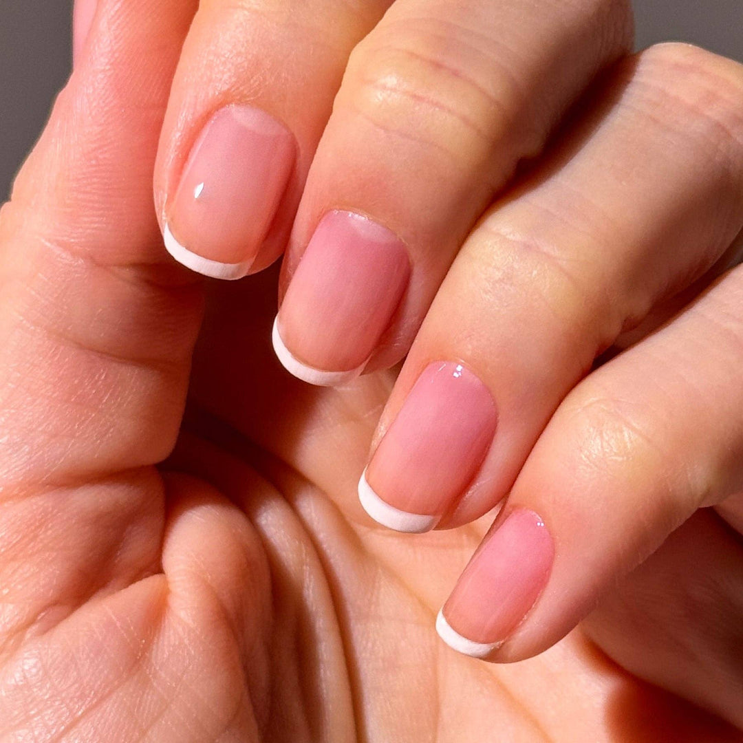 Close-up of hands with pink nail polish and white tips