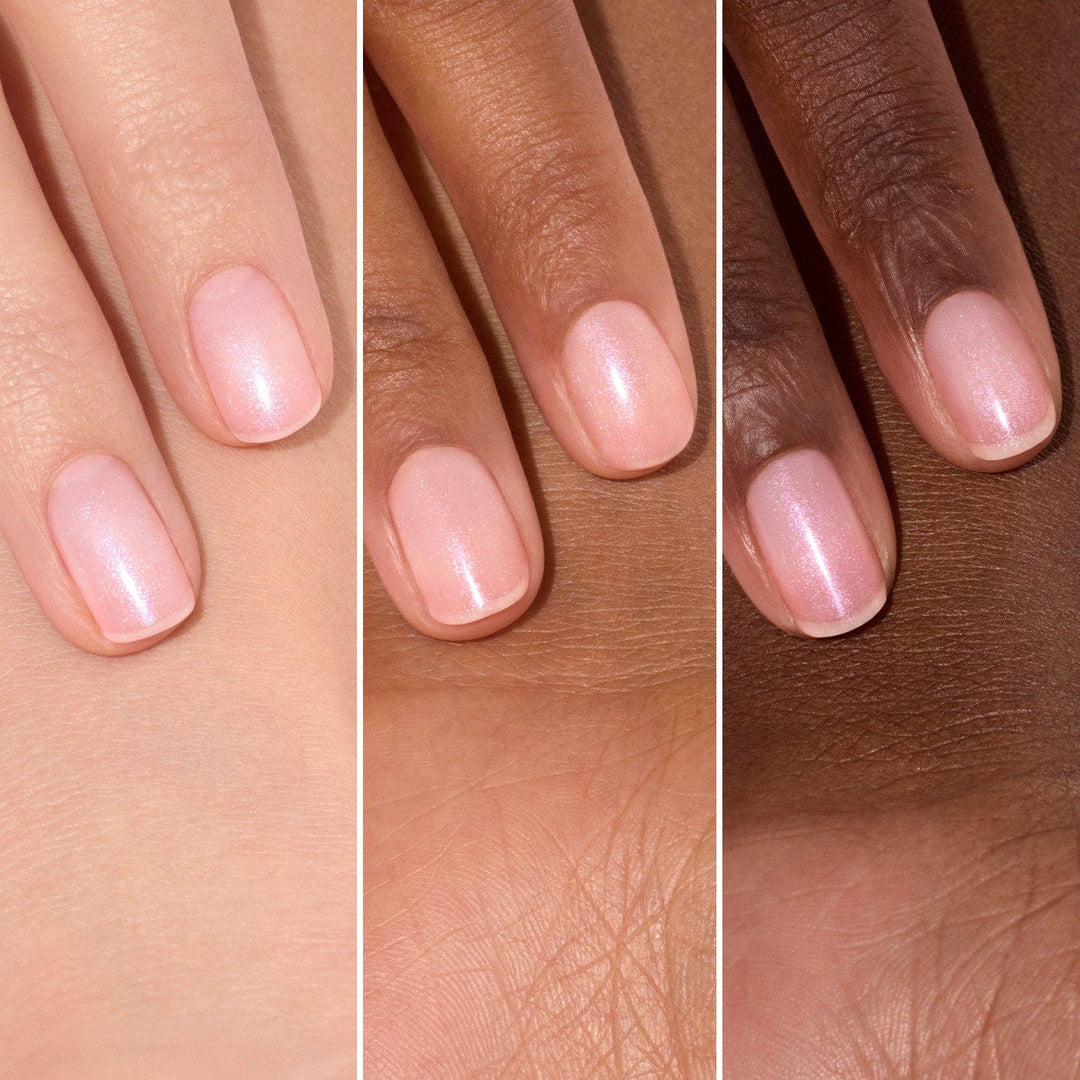 Three hands with light pink nail polish on a neutral background