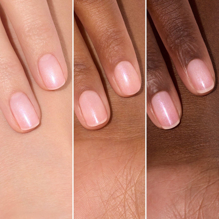 Three hands with light pink nail polish on a neutral background