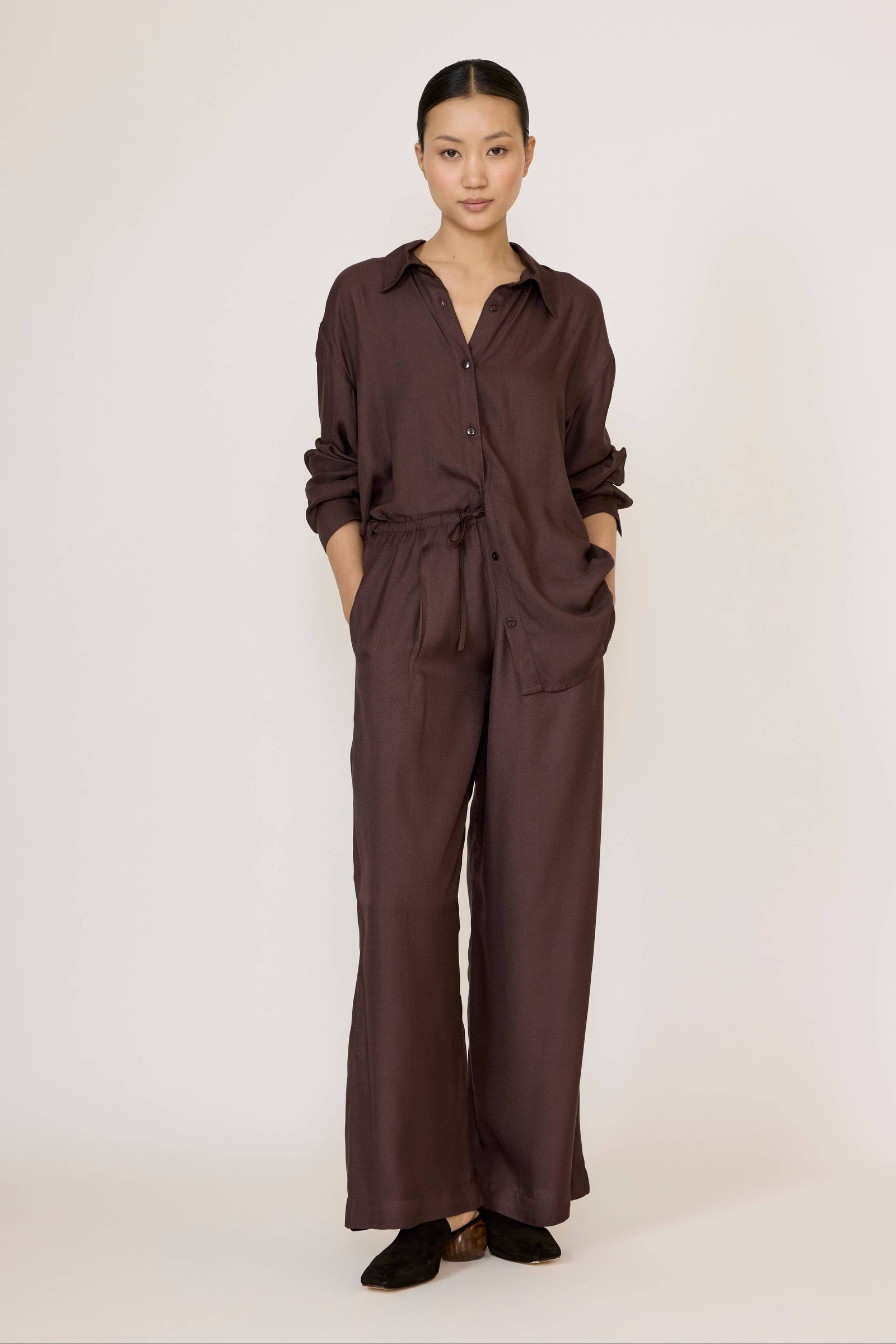 Woman wearing Laude's Easy Pant in Chocolate Brown with a matching top on a white background