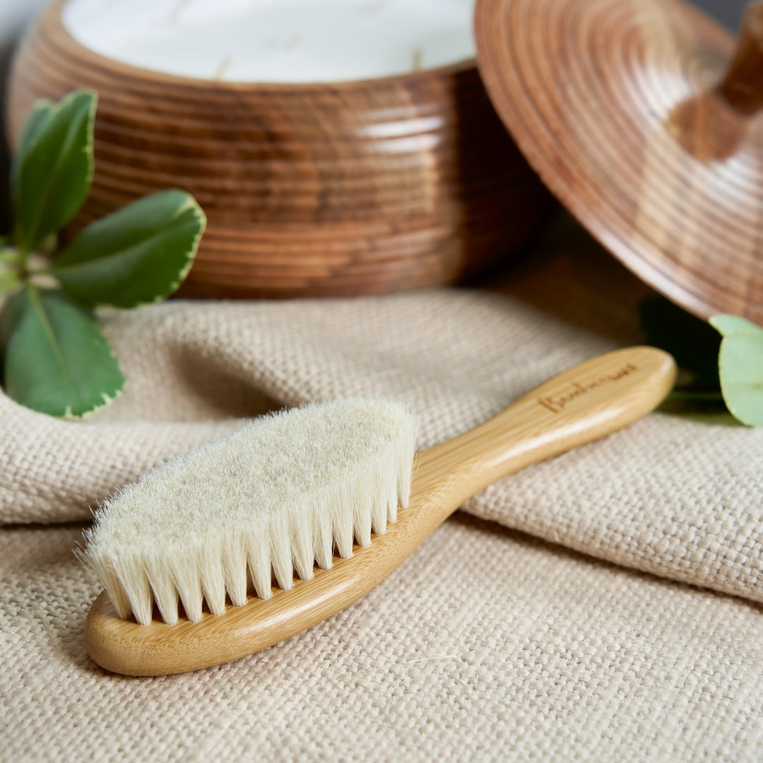 Wooden brush with natural bristles on a beige fabric background
