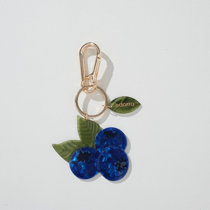 Keychain with blue berry design and gold clasp on a white background