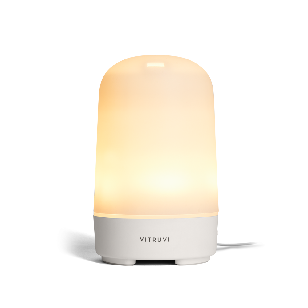 Vitruvi diffuser with light on with a gradient design on a white background