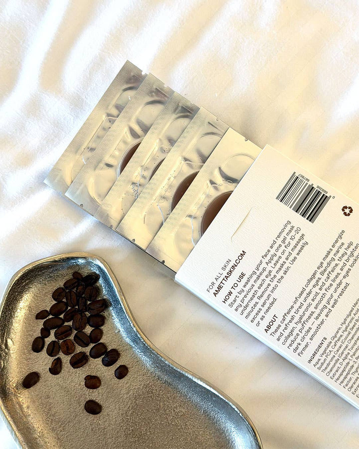 Back of Ametta eye patch box next to coffee beans on a white surface