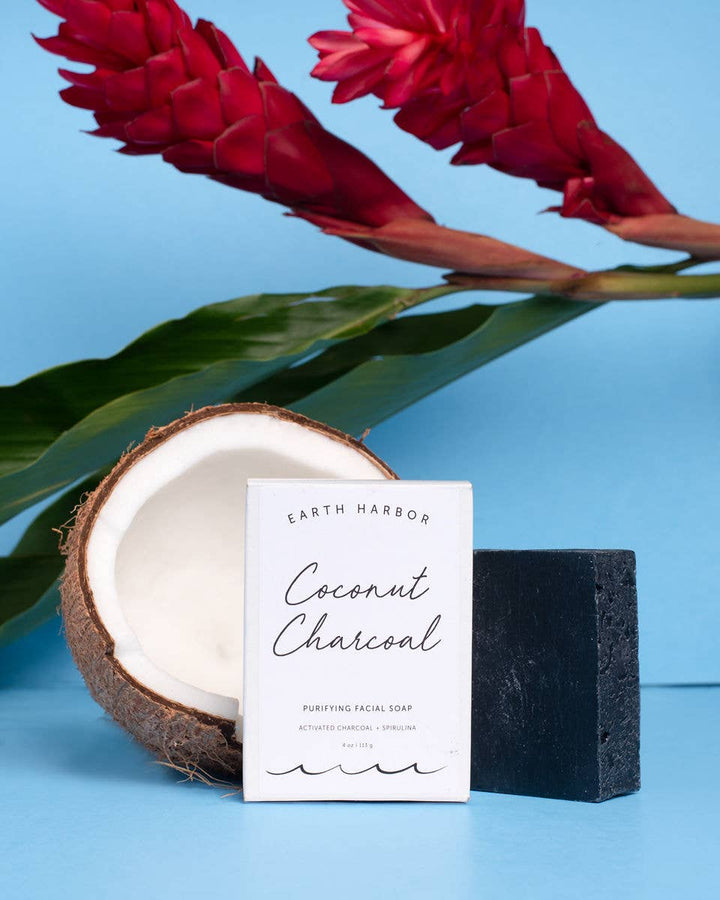 Coconut Charcoal soap bar with a half-coconut and red flowers on a blue background