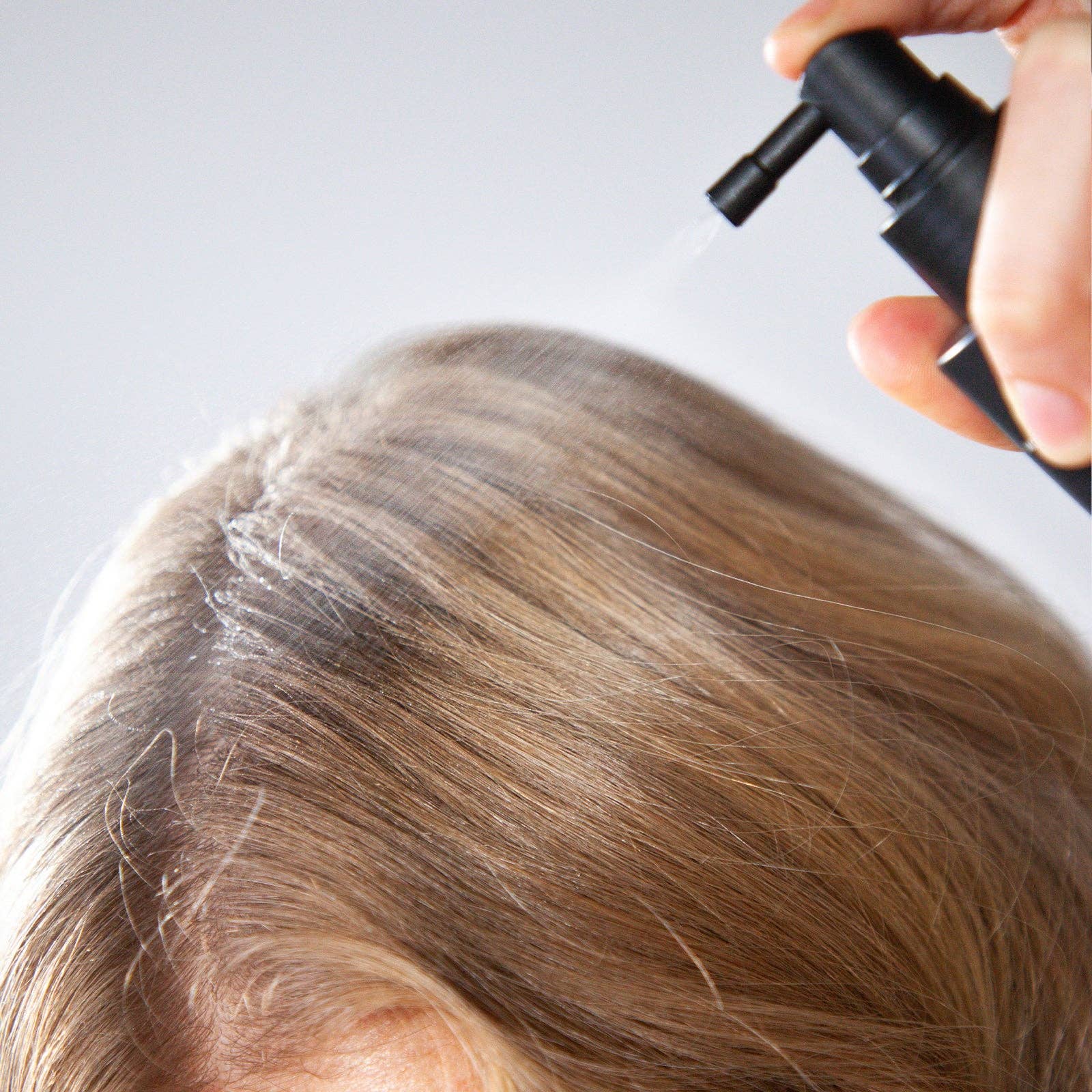 Person applying copper sequence to light colored hair.