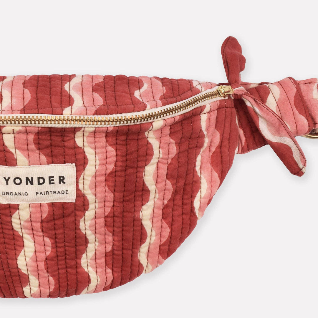 Red and white patterned bag with a gold zipper on a white background, featuring the &