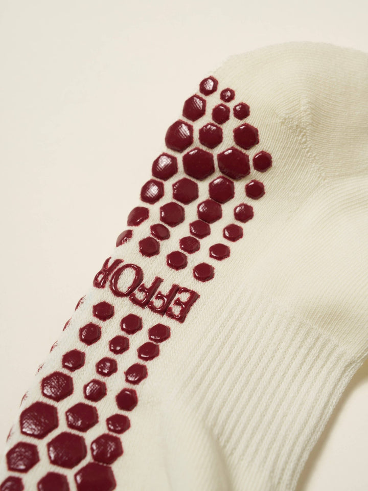Close-up of a white sock with red grips and &