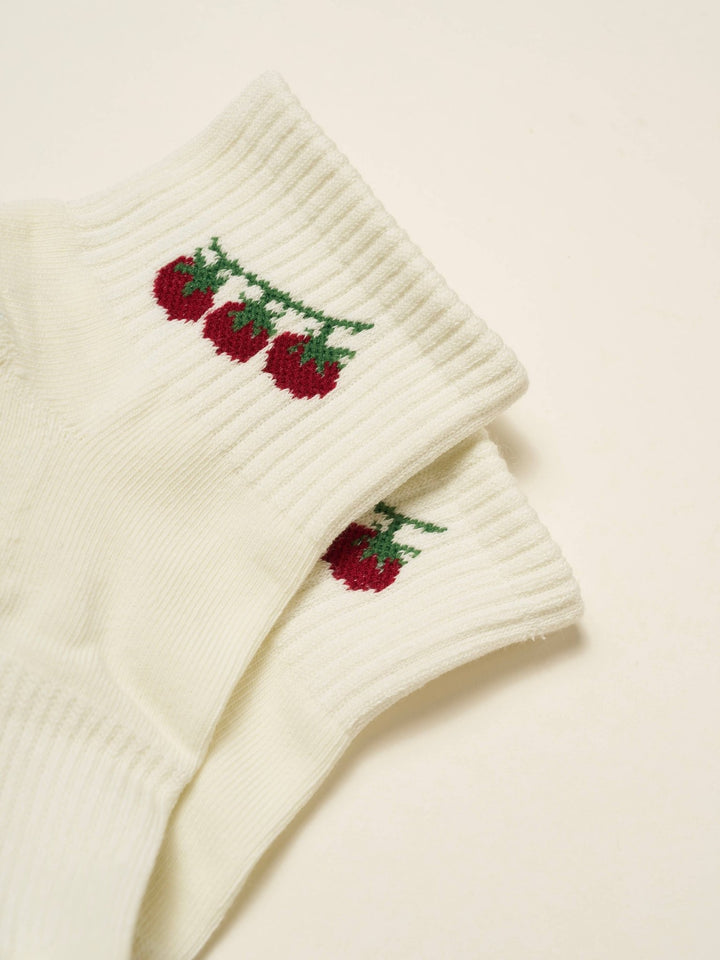 Pair of pilates socks with tomato design 
on a beige background