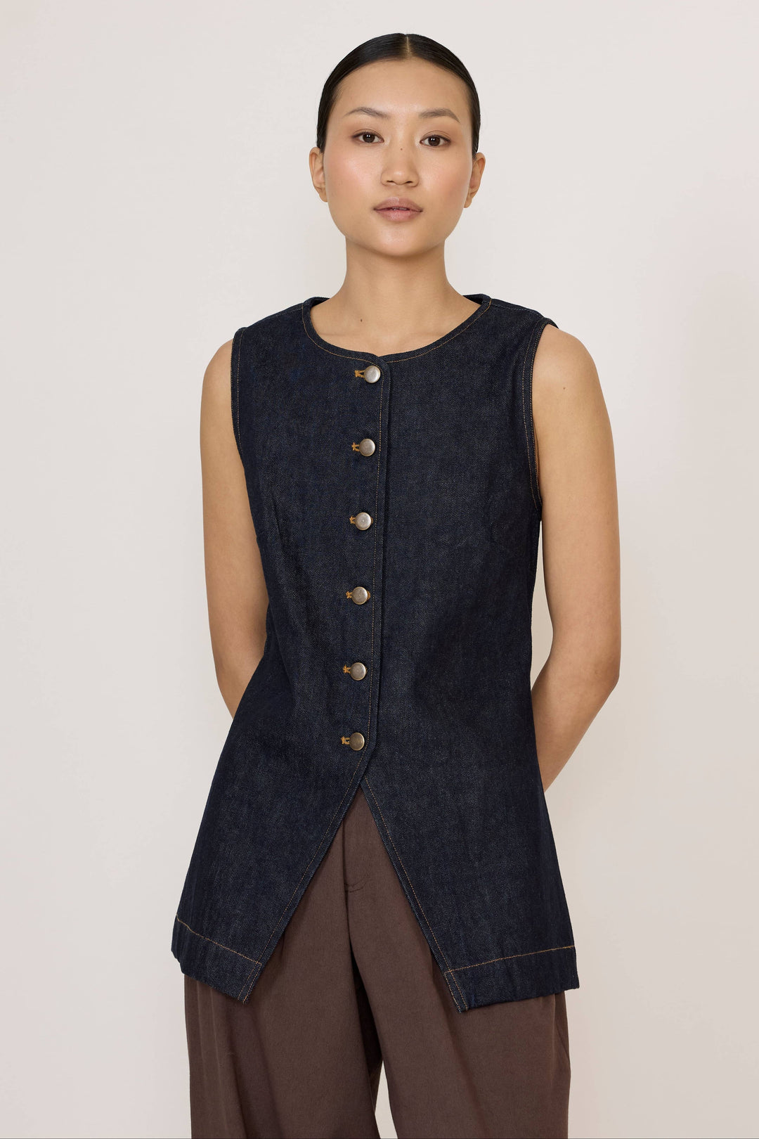 Woman wearing a Laude Longline Vest in Dark Indigo over a plain background
