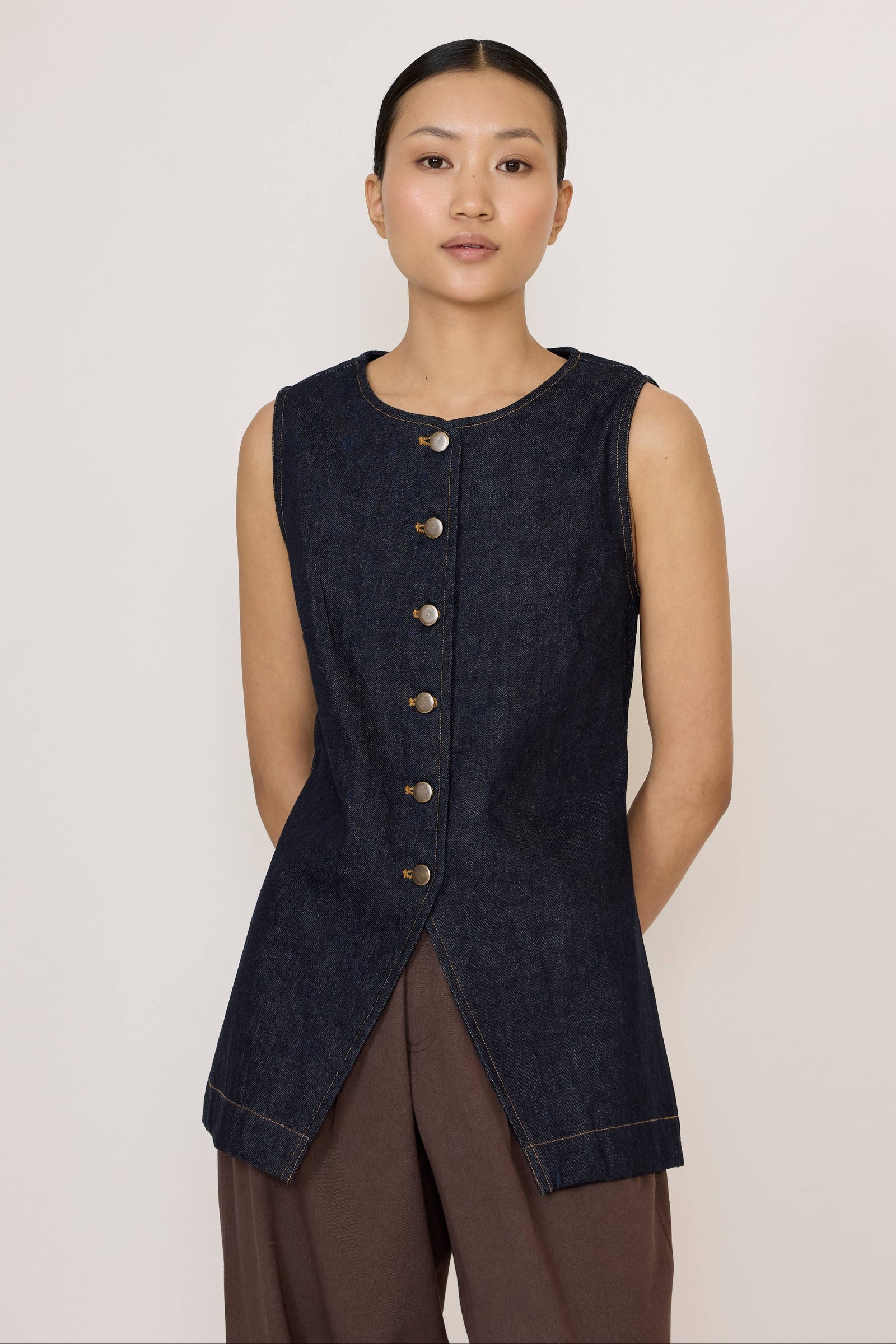 Woman wearing a Laude Longline Vest in Dark Indigo over a plain background