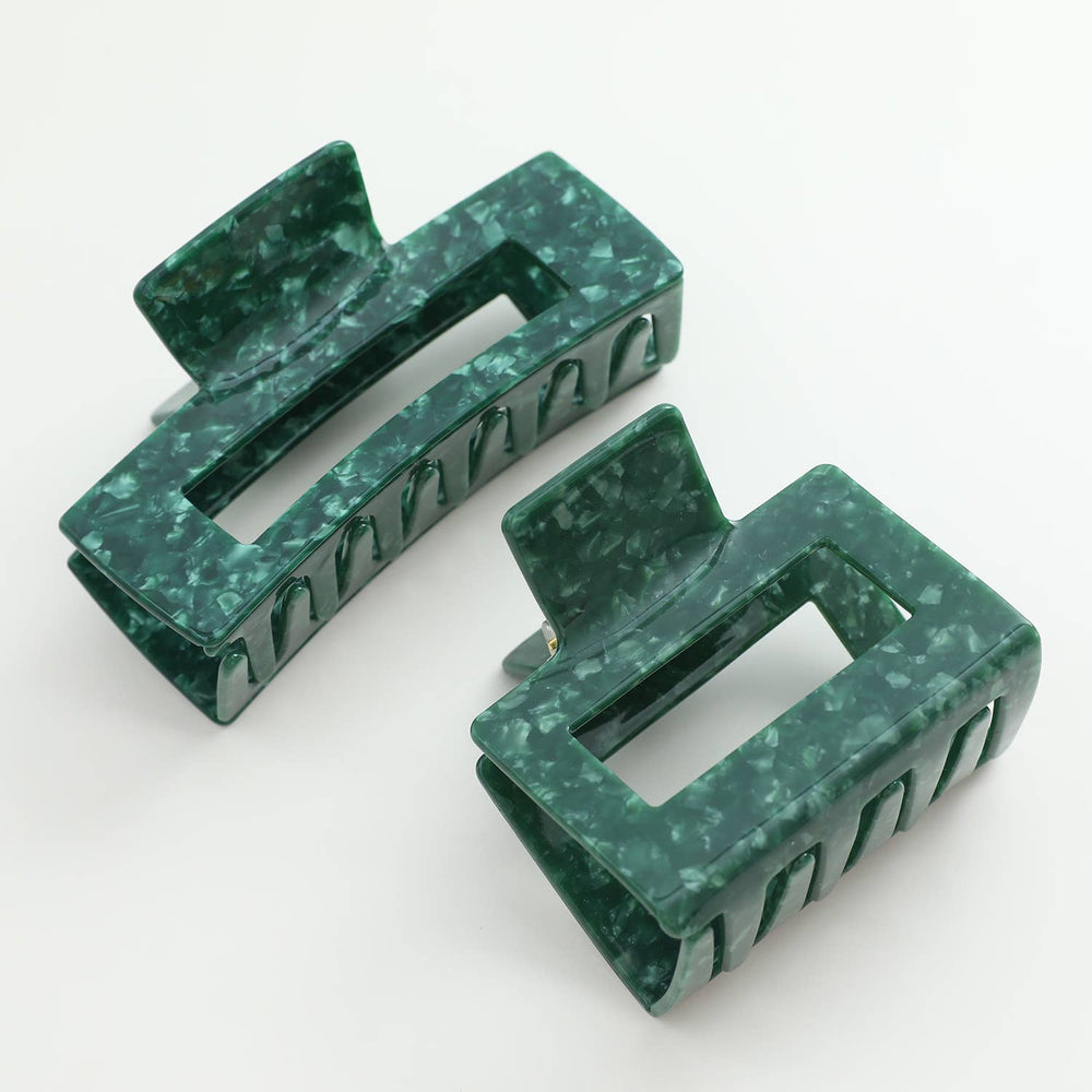 Two green marble-textured hair clips on a white background