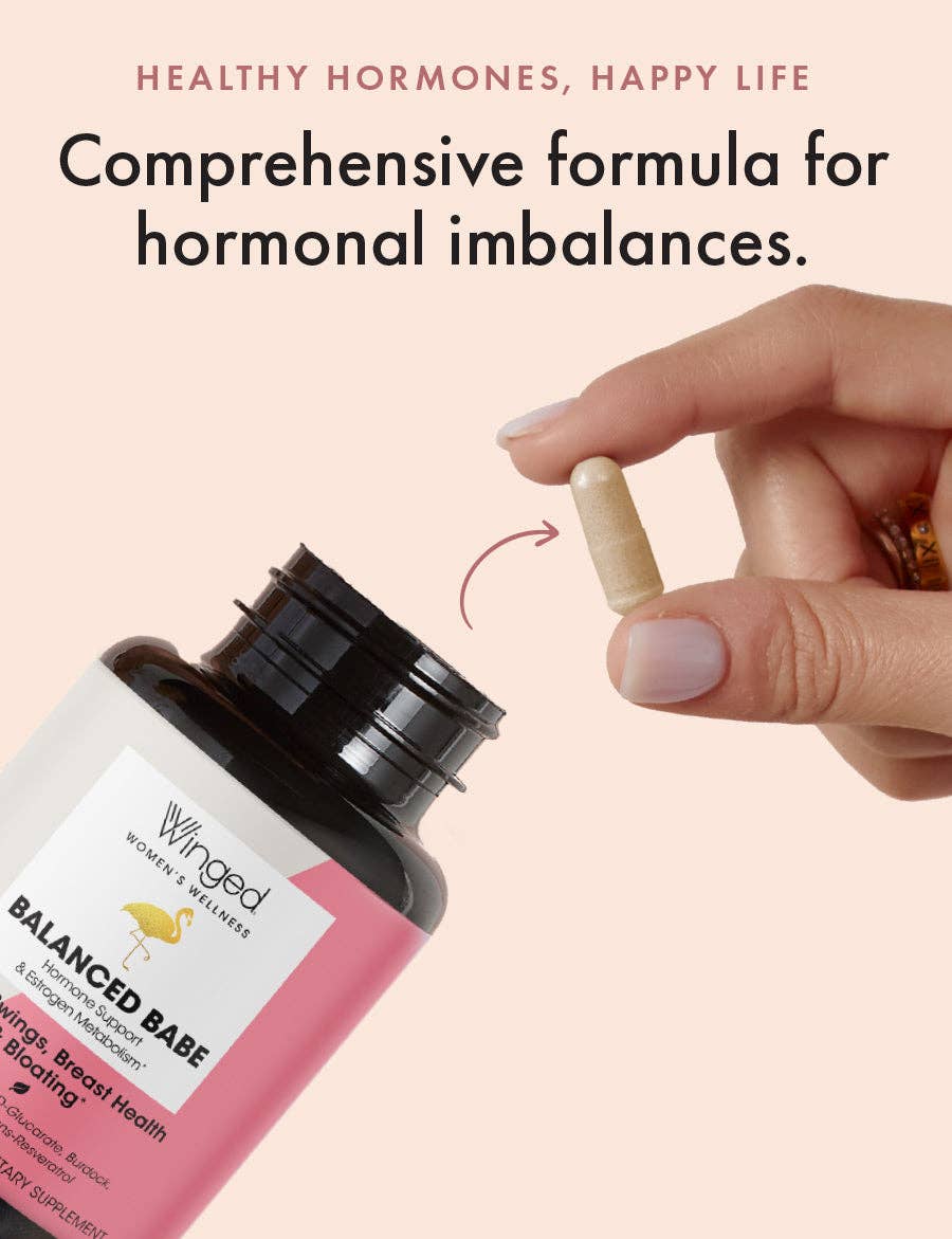 Supplement bottle labeled 'Balanced Babe' with a hand holding a capsule against a pink background.