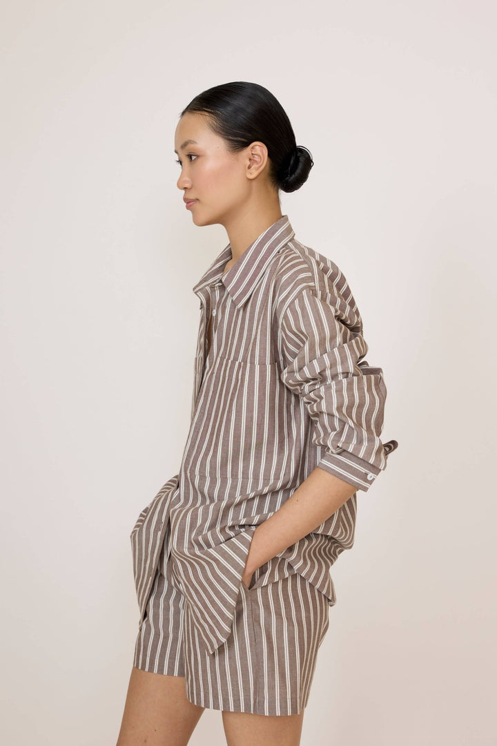 Woman wearing a Laude Everything Shirt in Acorn Stripe and matching shorts set on a plain background