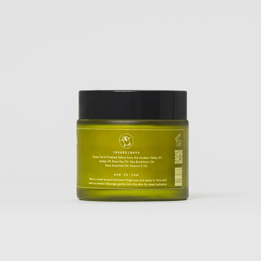 Green jar of Tallow showing ingredients and 'how to use' instructions with black lid on a white background