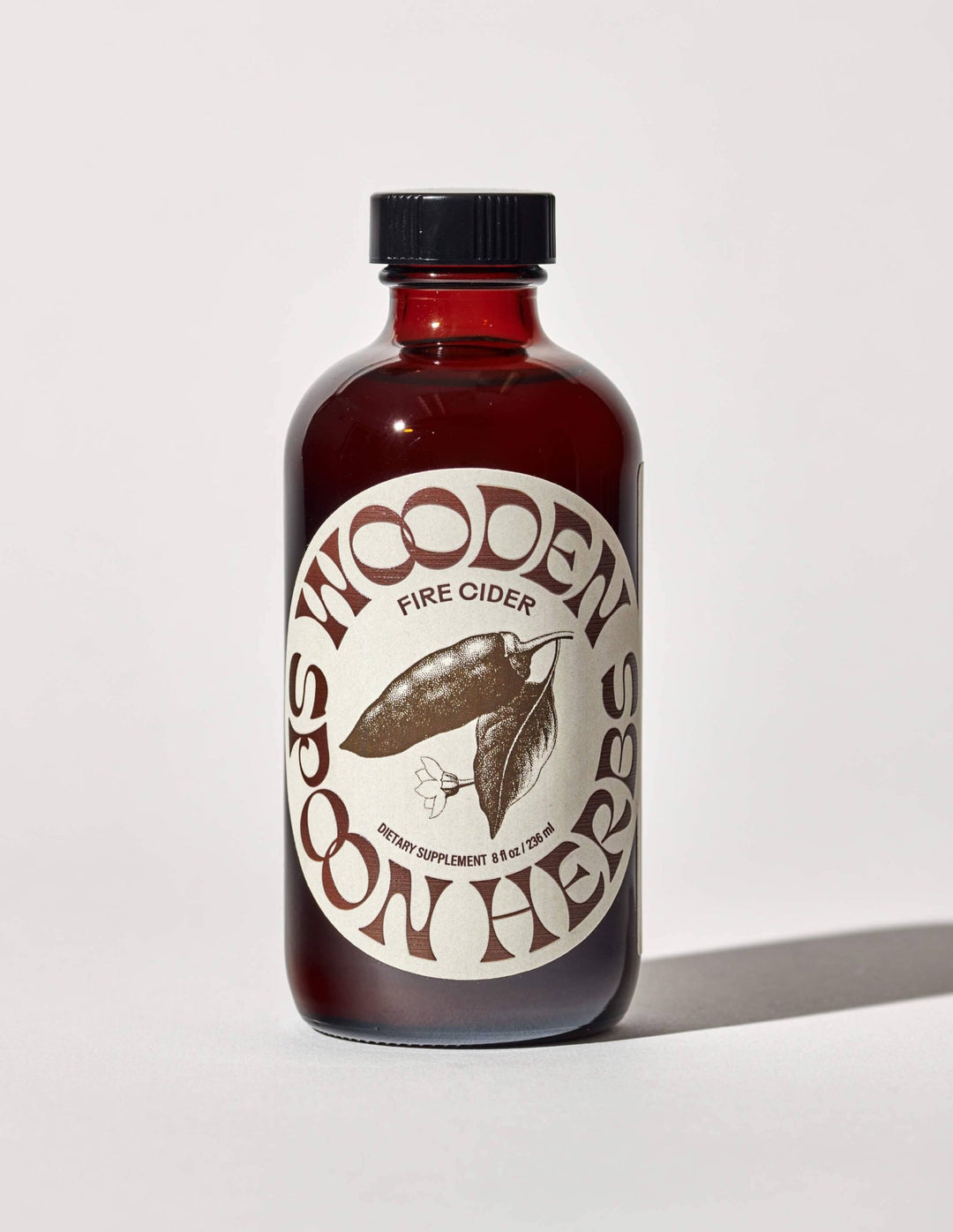 Bottle of Wooden Spoon Herbs Fire Cider on a white background