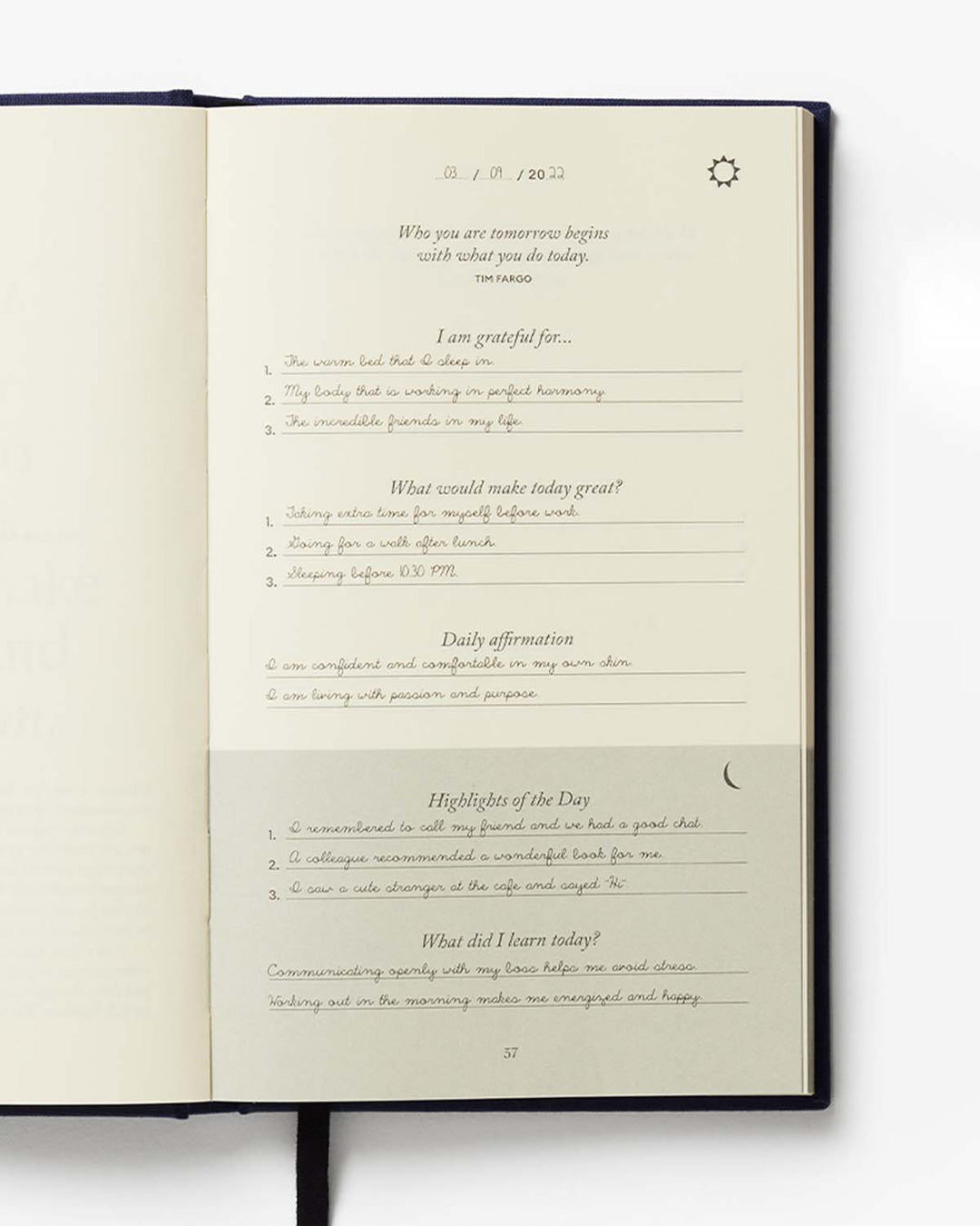 Open journal with daily reflection prompts on a white background