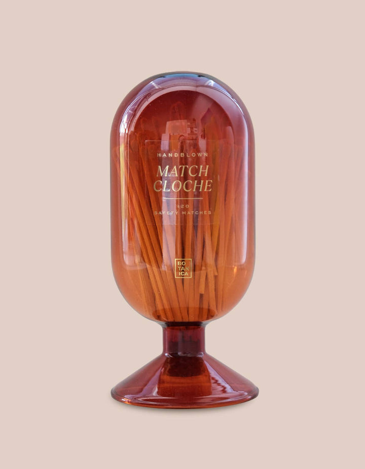 Match Cloche container with wooden matches on a beige background