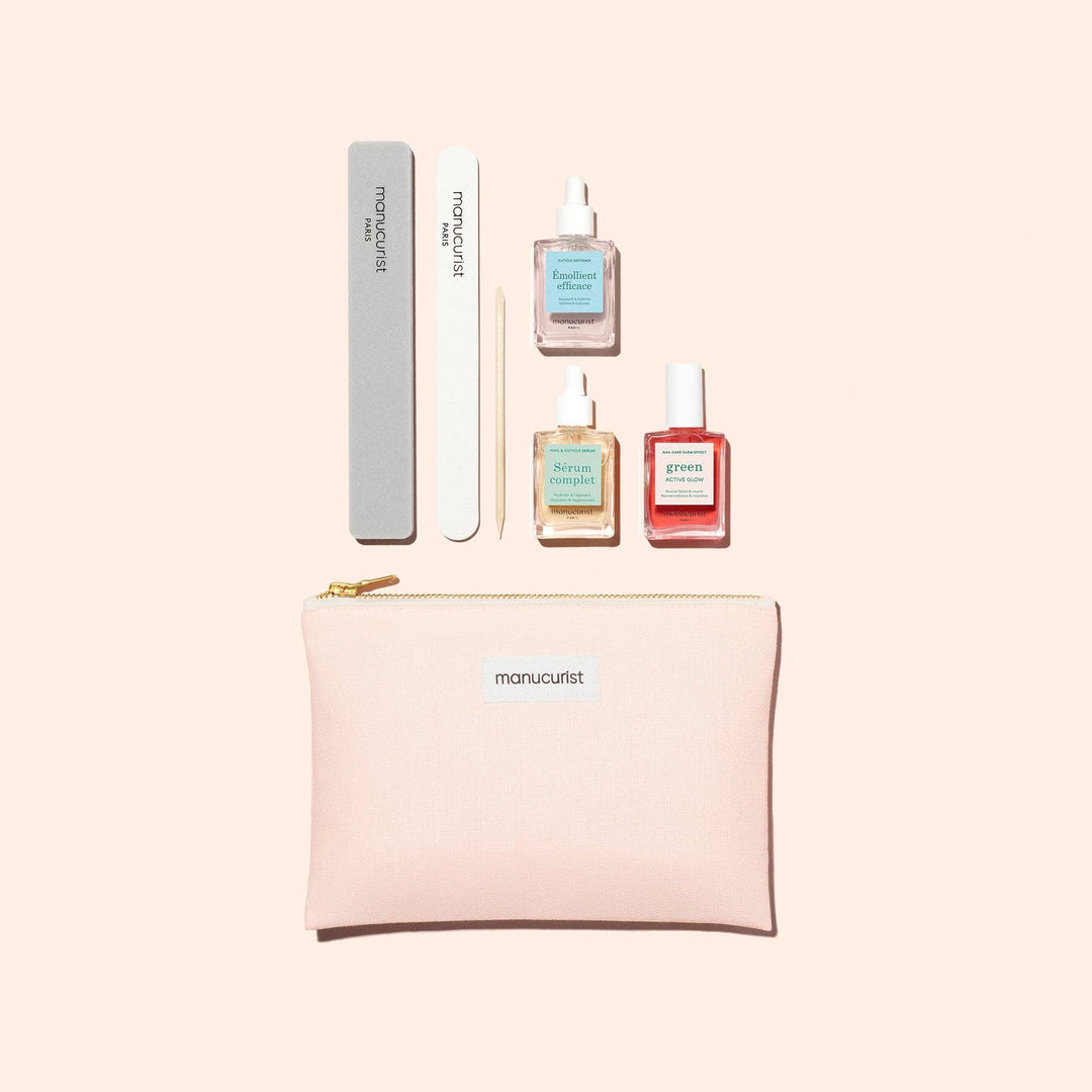 Manucurist nail care set with pink pouch, nail polishes, and tools on a light beige background