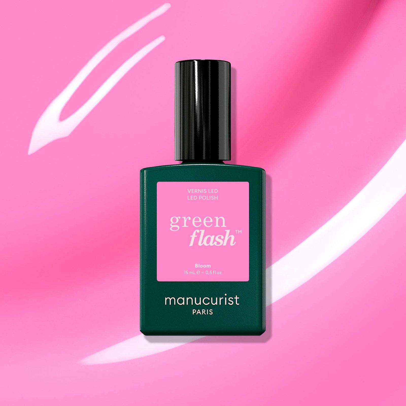 Manucurist green flash nail polish bottle on a pink background