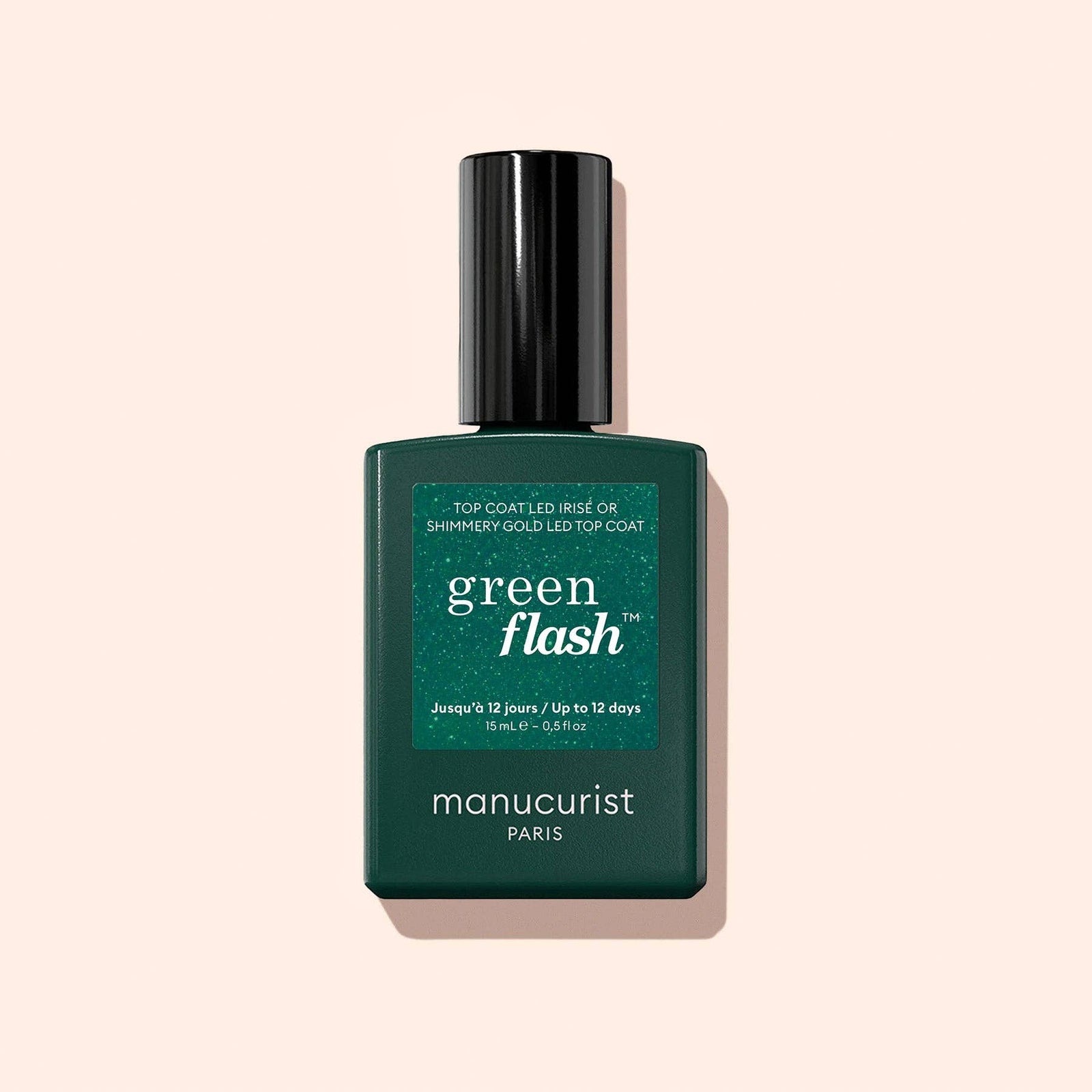 Manucurist Green Flash nail polish bottle on a beige background