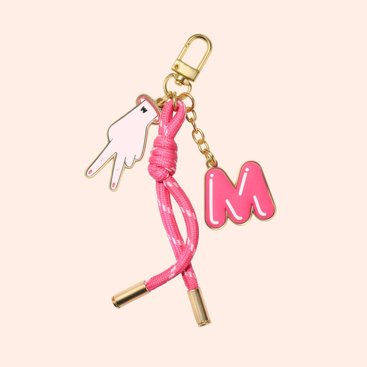 Bag Charm with pink M, chord, and peace sign.