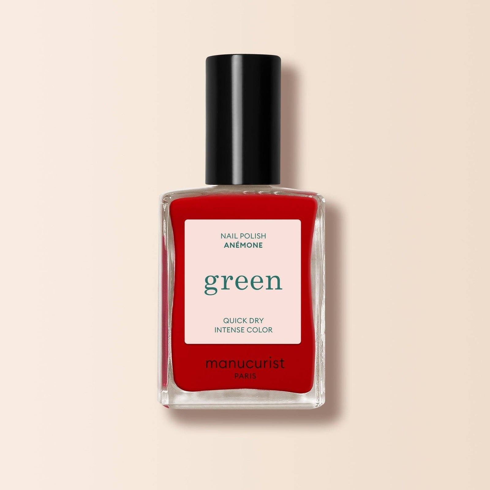Red manucurist nail polish bottle with black cap on a beige background