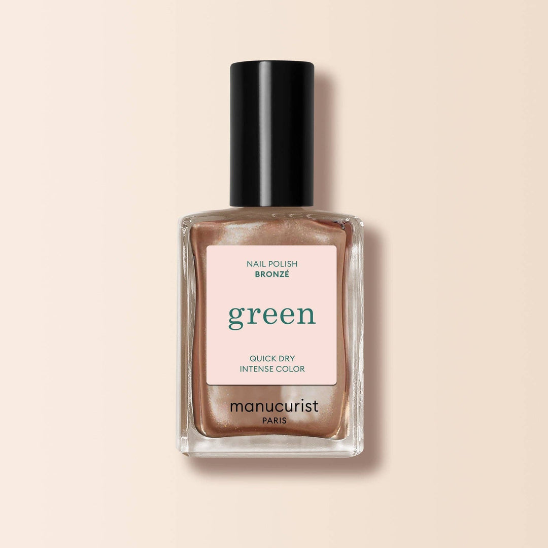 Manucurist nail polish bottle with bronze color on a beige background