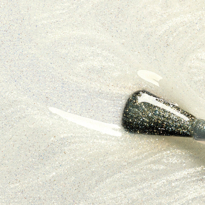Close-up of a gold glittery top coat swatch