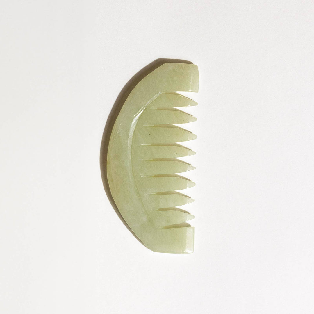 Green jade comb on a white background